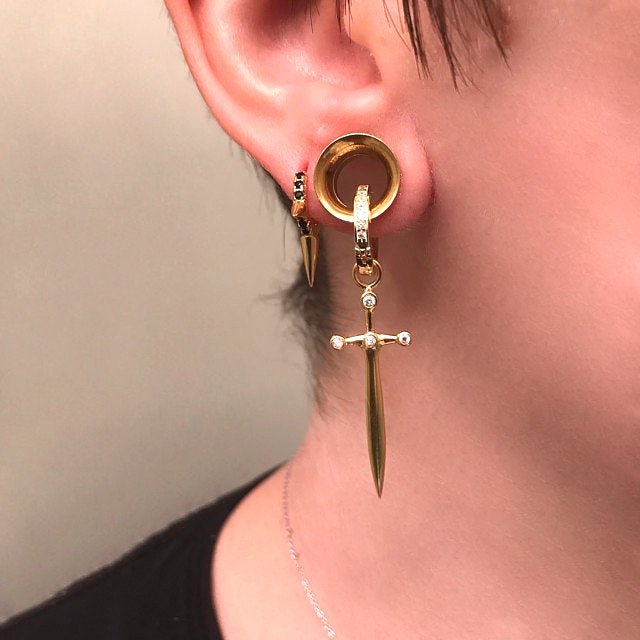 A model wearing the CZ Sword Earrings through her gauges.