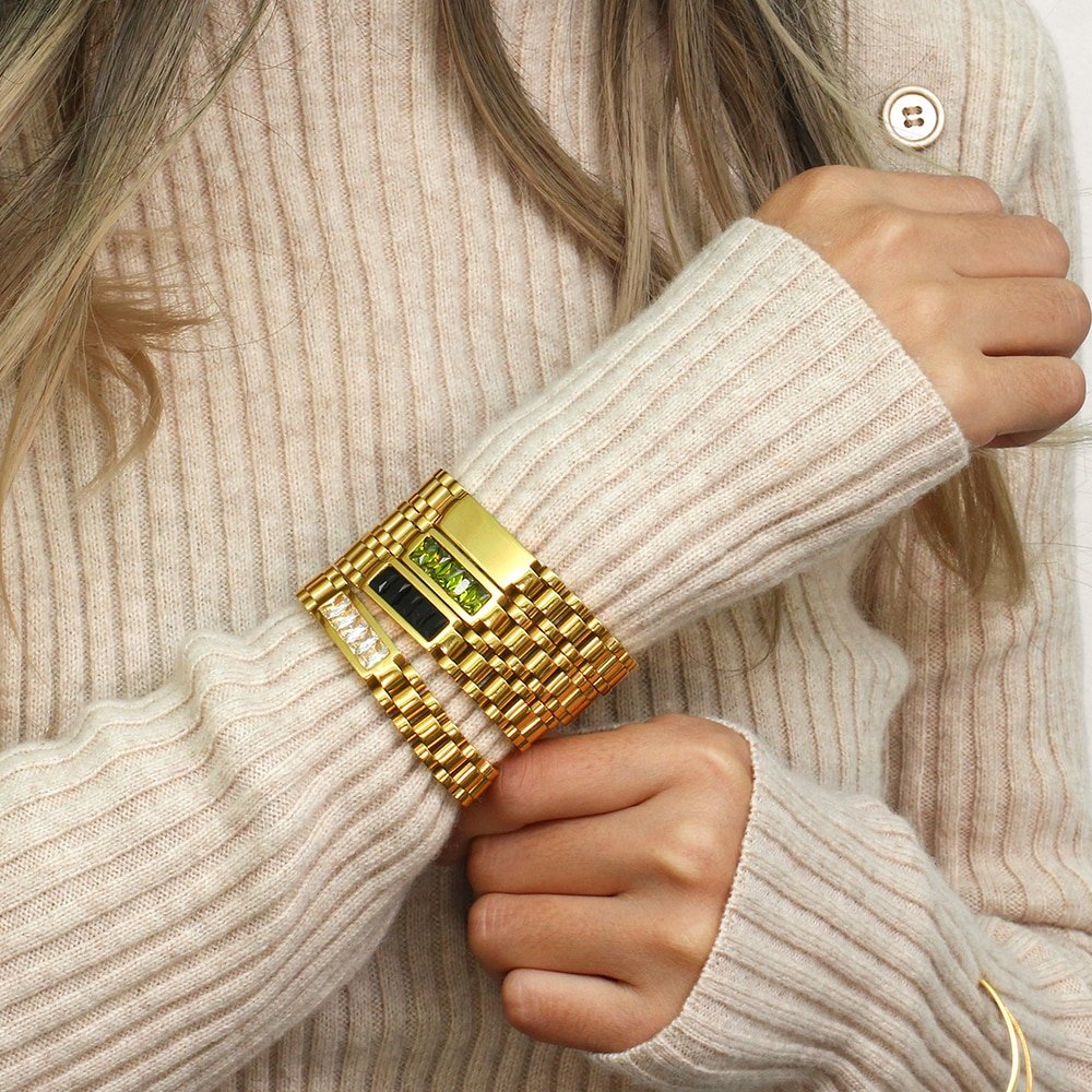 A model wearing gold watchband bracelets.