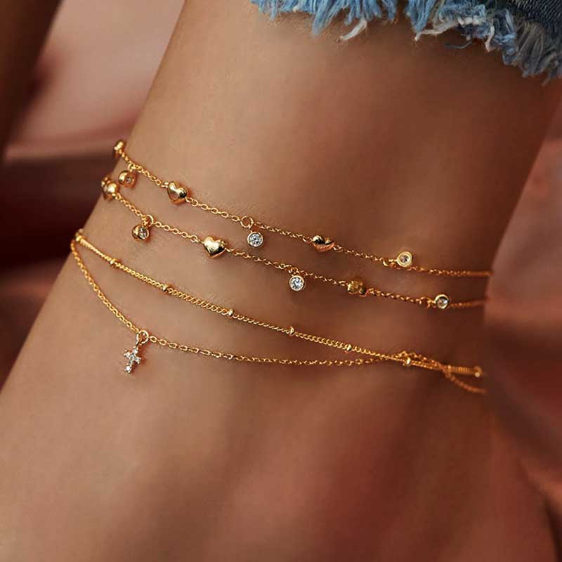 A model wearing the Dainty Cross Gold Anklet Set.