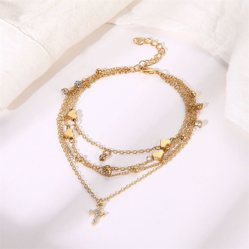 Multi-chain gold anklet set with cross charm.