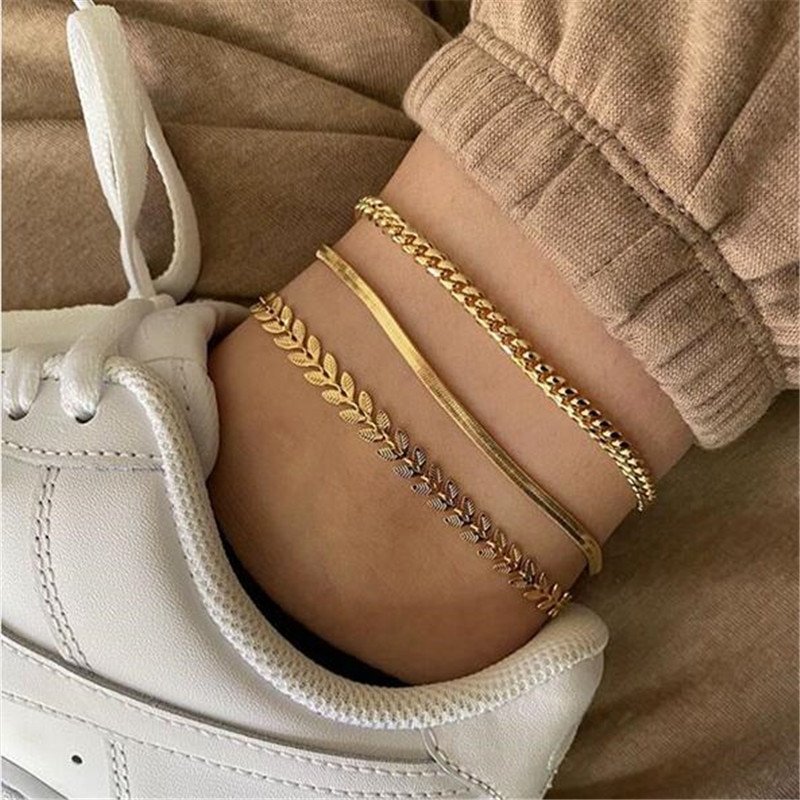 A model wearing the Evelyn Gold Anklet Set with sneakers.