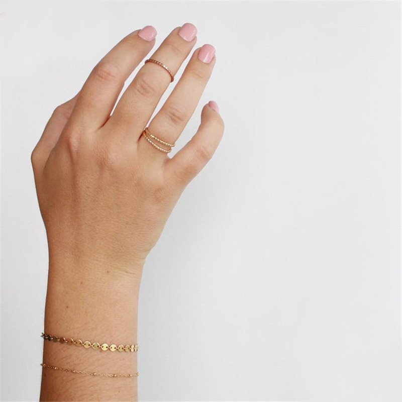A model wearing minimal rings and bracelets.