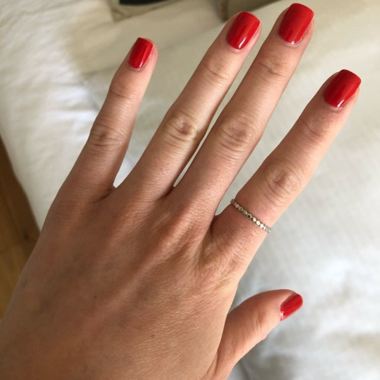 A woman wearing a simple minimal ring band.