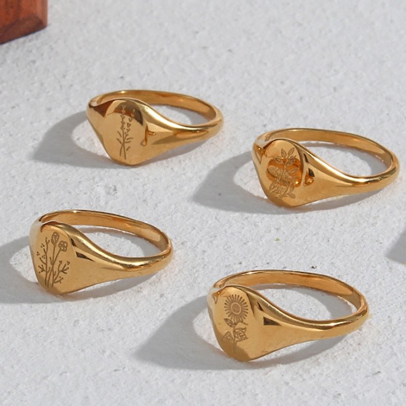 Four gold floral signet rings.