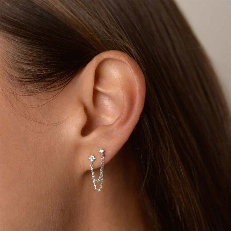 A woman wearing the Flower Double Stud Chain Earrings.