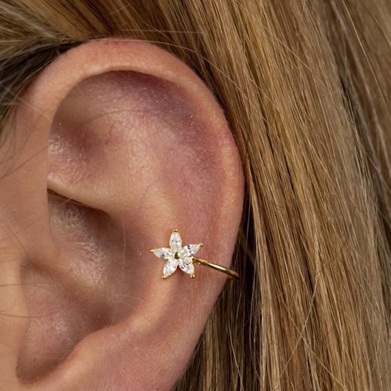 A woman wearing a single Flower Zirconia Ear Cuff.