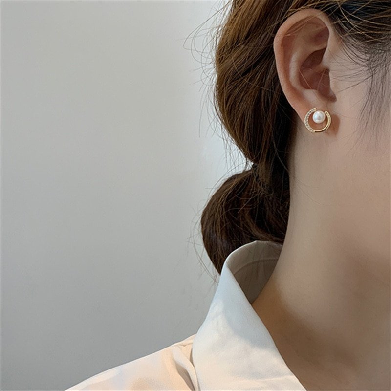 A woman wearing the Galactic Pearl Studs in Gold.