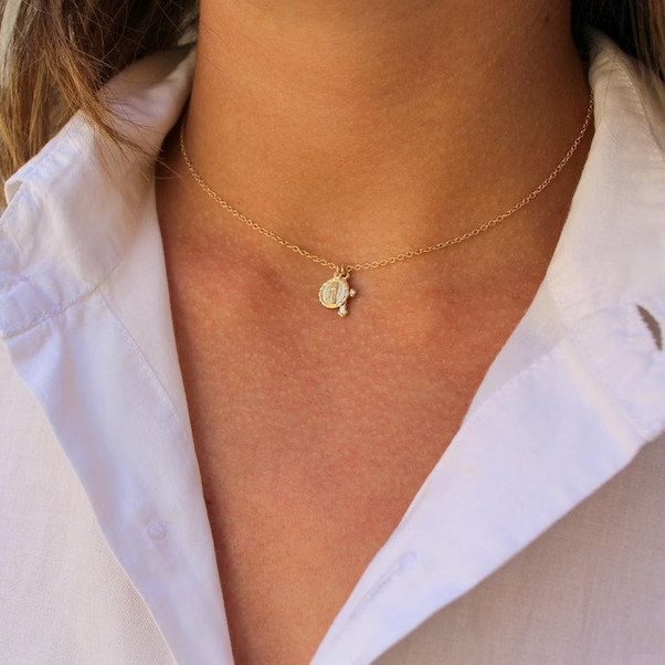 A woman wearing the Gold Cross Charm Necklace.