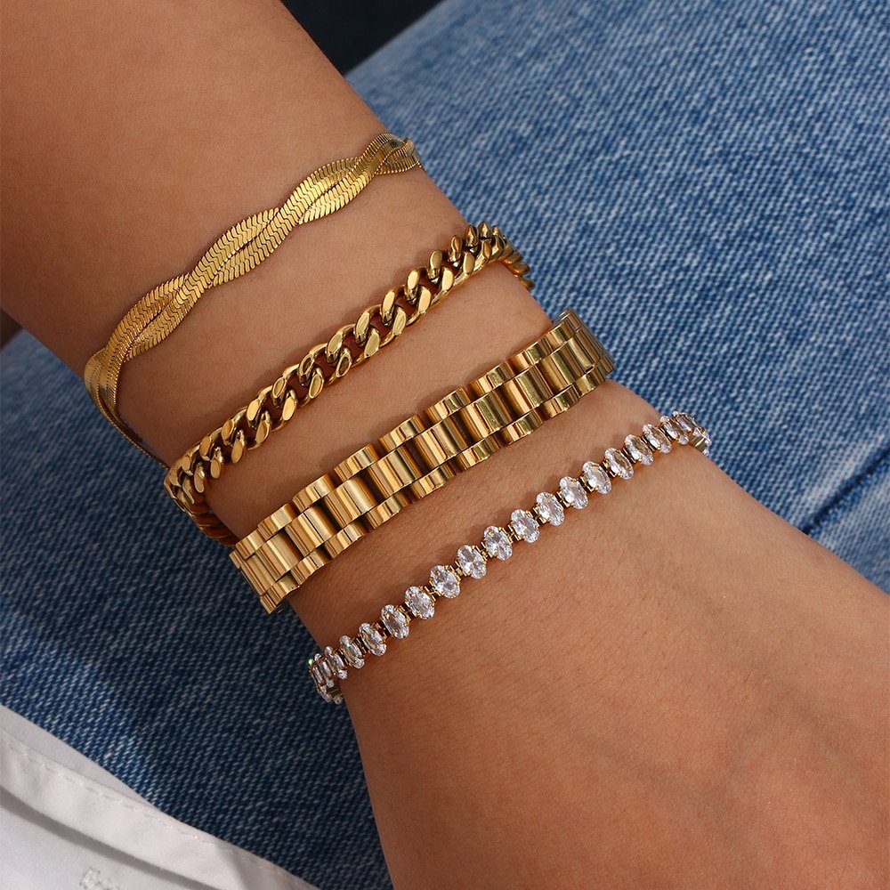 A model wearing multiple gold bracelets.