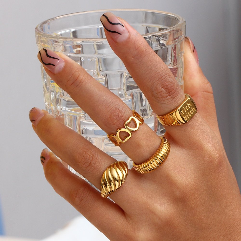 A woman wearing multiple gold rings.
