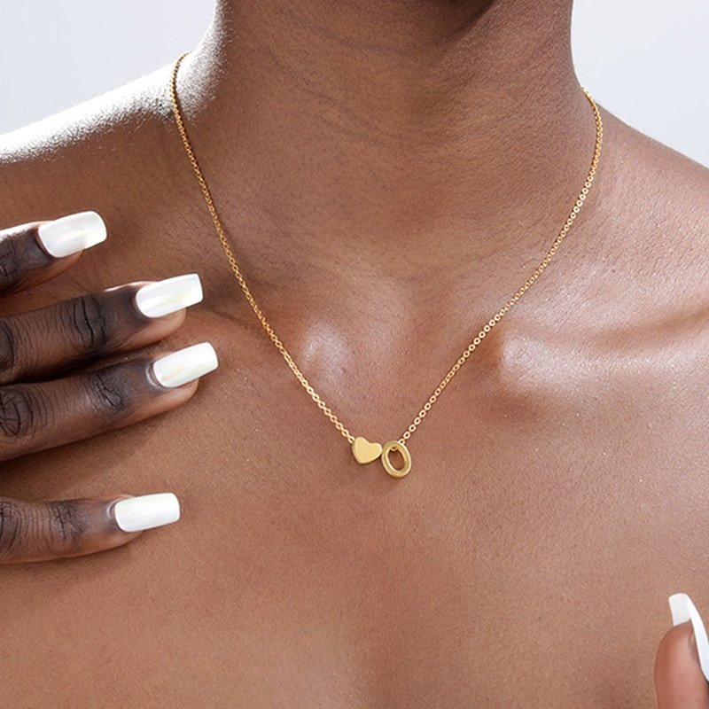 A model wearing a gold Heart Initial Necklace.