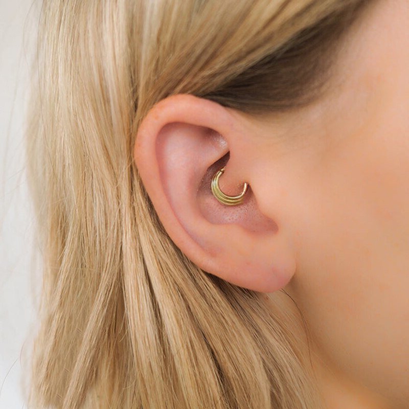 A model wearing an ethnic style daith cartilage earring.