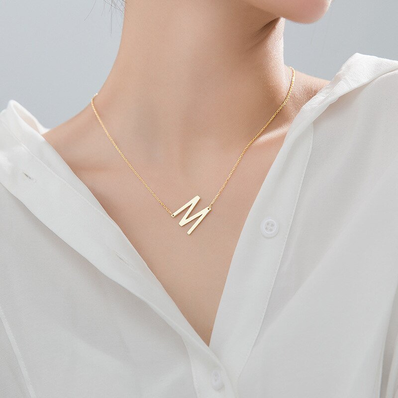 A model wearing a letter M Large Asymmetrical Initial Necklace.