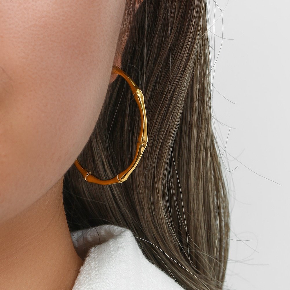 A model wearing the Large Gold Bamboo Hoop earrings.
