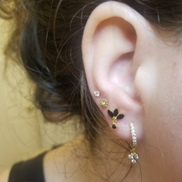 A woman wearing multiple stud earrings.