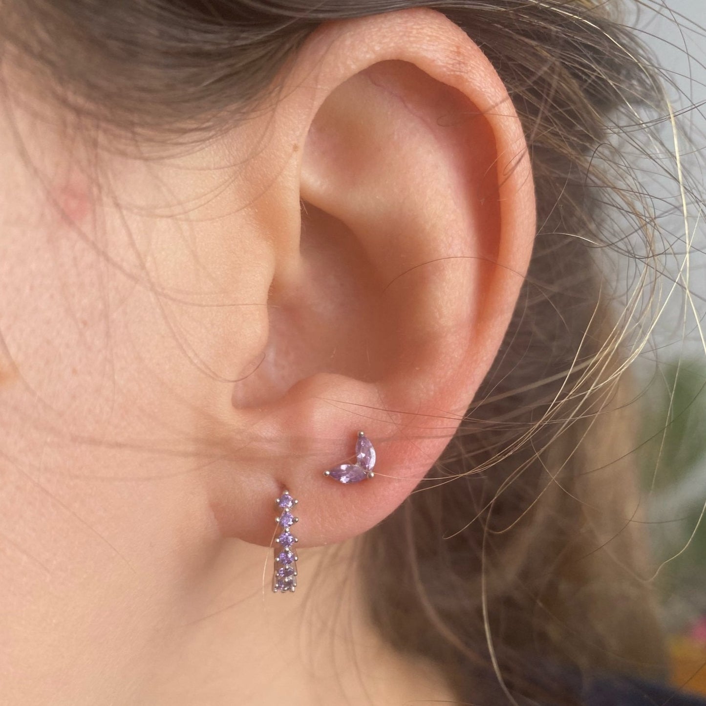 A woman wearing silver Lilac CZ Huggies with Lilac Marquise Studs.