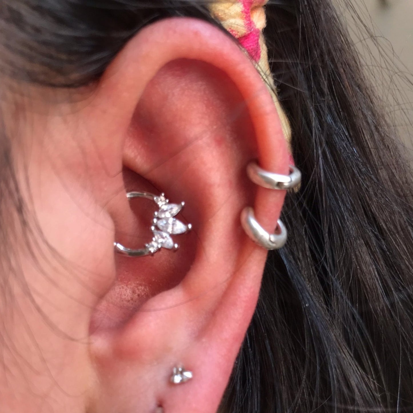 A woman wearing silver cartilage hoop piercings.