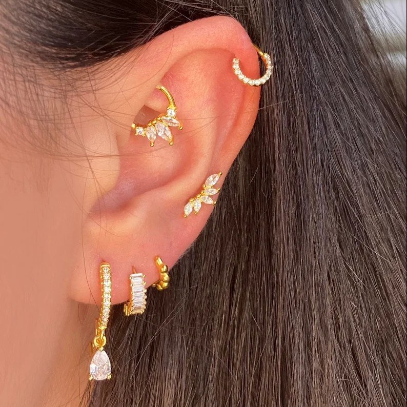 A woman wearing multiple gold CZ piercings.