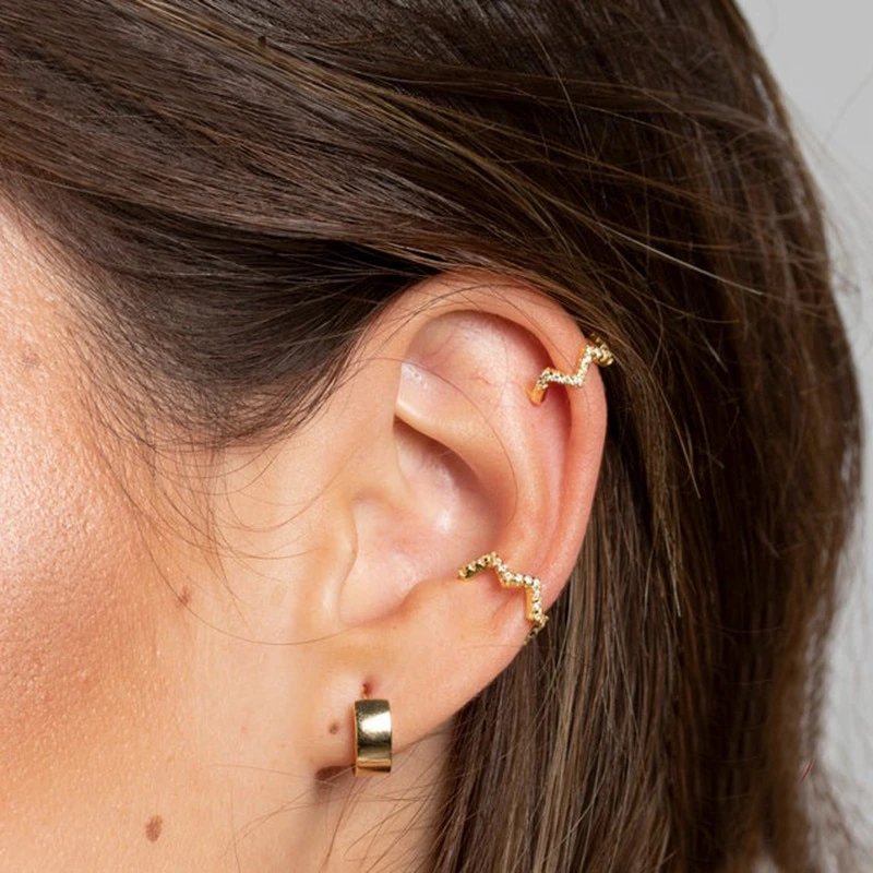 A model wearing multiple Micro CZ Pave Wave Ear Cuff.