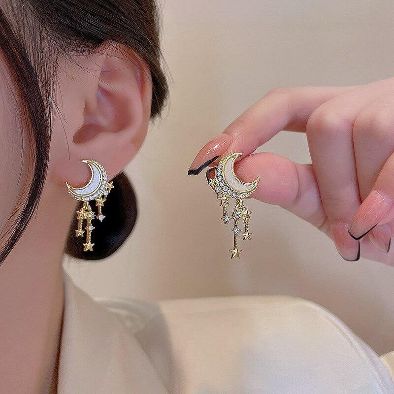 A woman wearing crescent moon statement earrings.