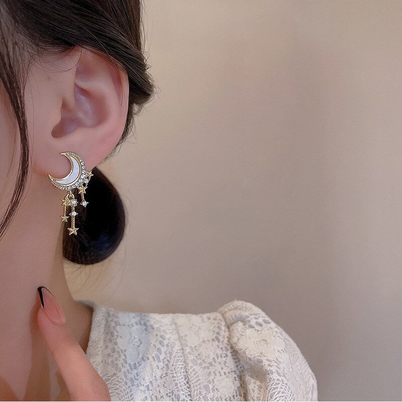 A woman wearing Moon Star Tassel Earrings.