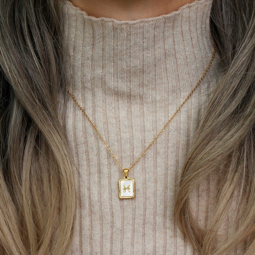 A model wearing a Mother of Pearl Zodiac Gold Necklace.