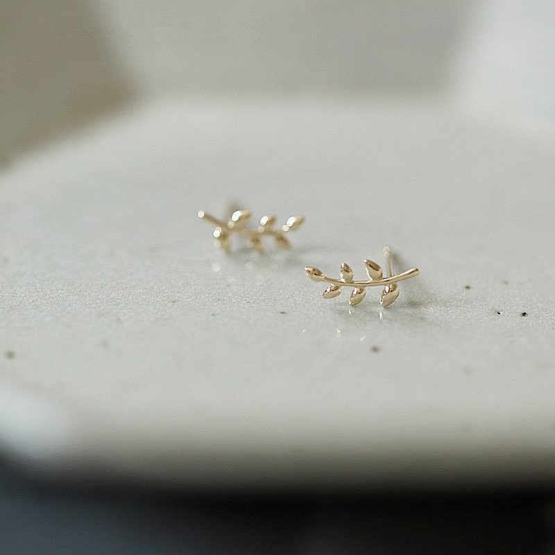 Closeup of tiny branch stud earrings.