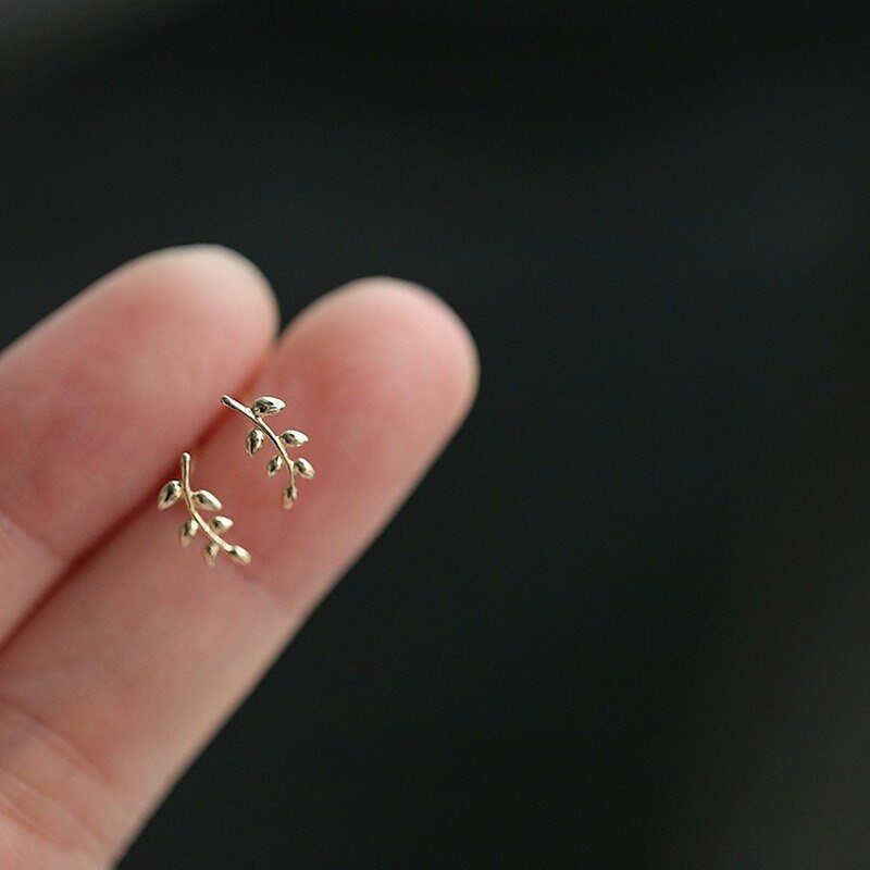 A model holding the Olive Branch Studs.