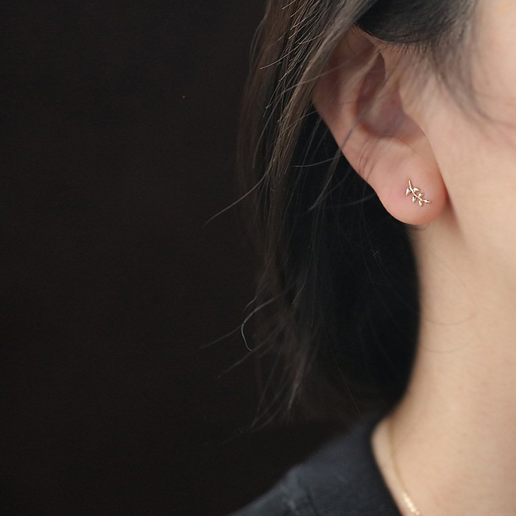 A model wearing the gold Olive Branch Stud earrings.