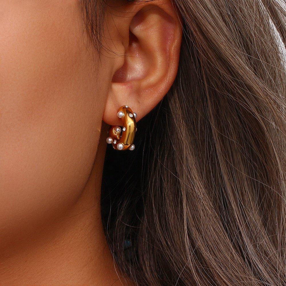 A woman wearing Pearl Barnacle Gold Hoops.