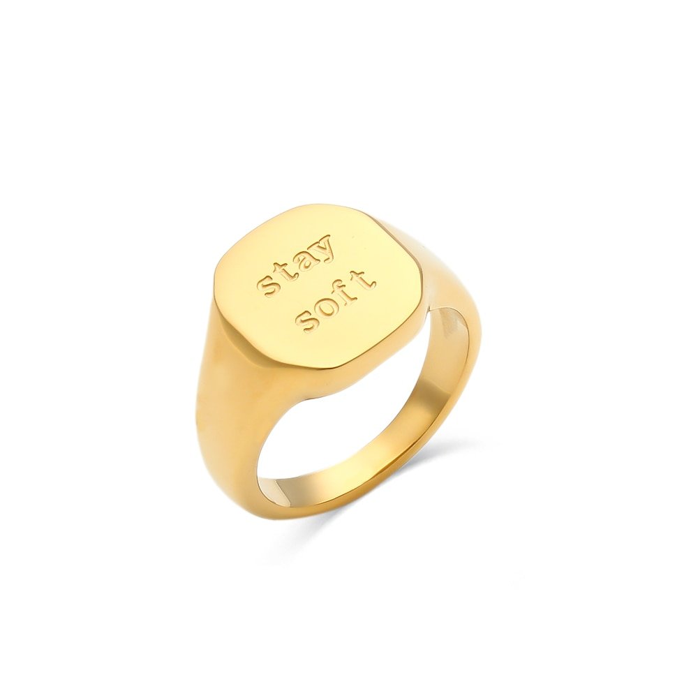 A gold chunky ring engraved with "Stay Soft".