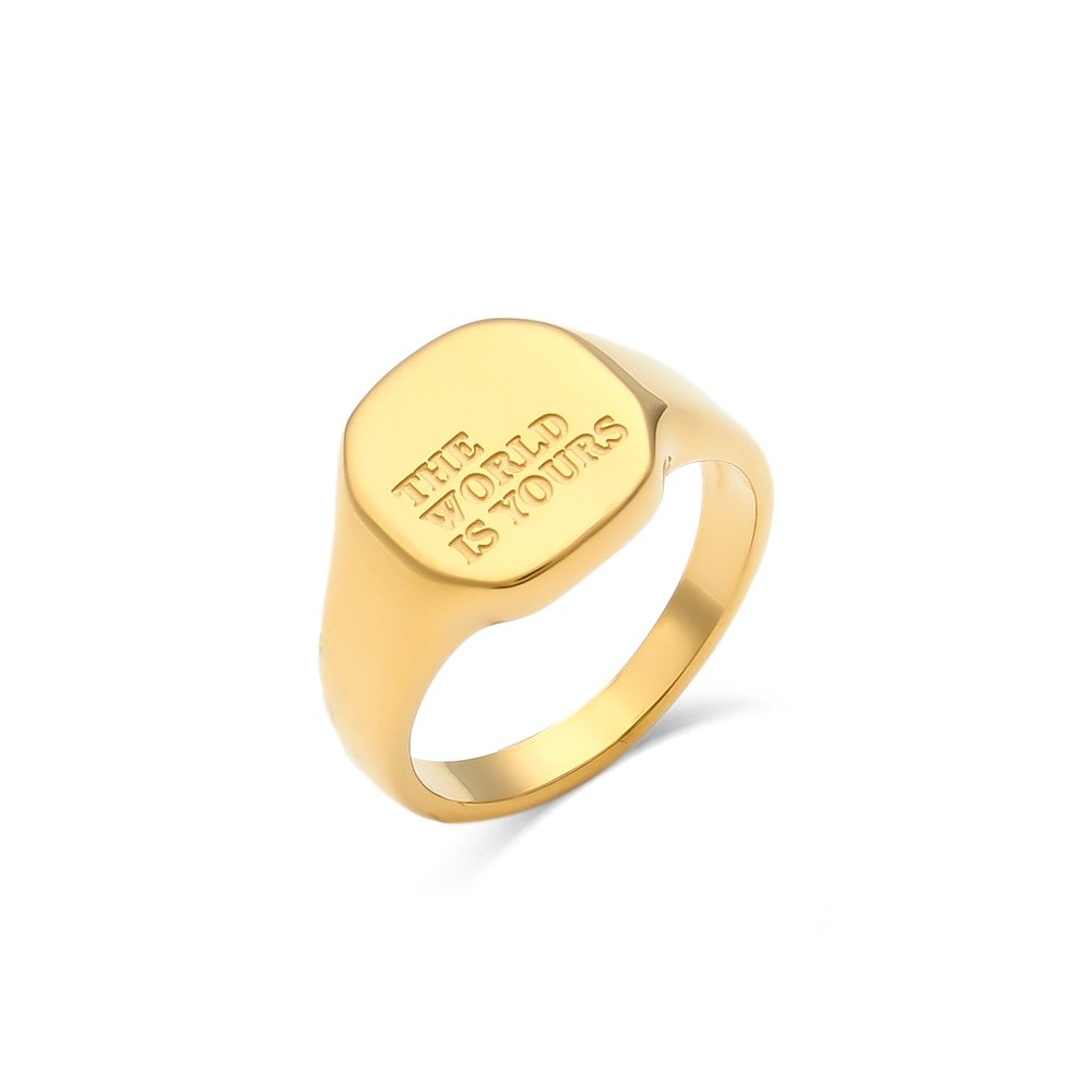 A gold chunky ring engraved with "The World is Yours".