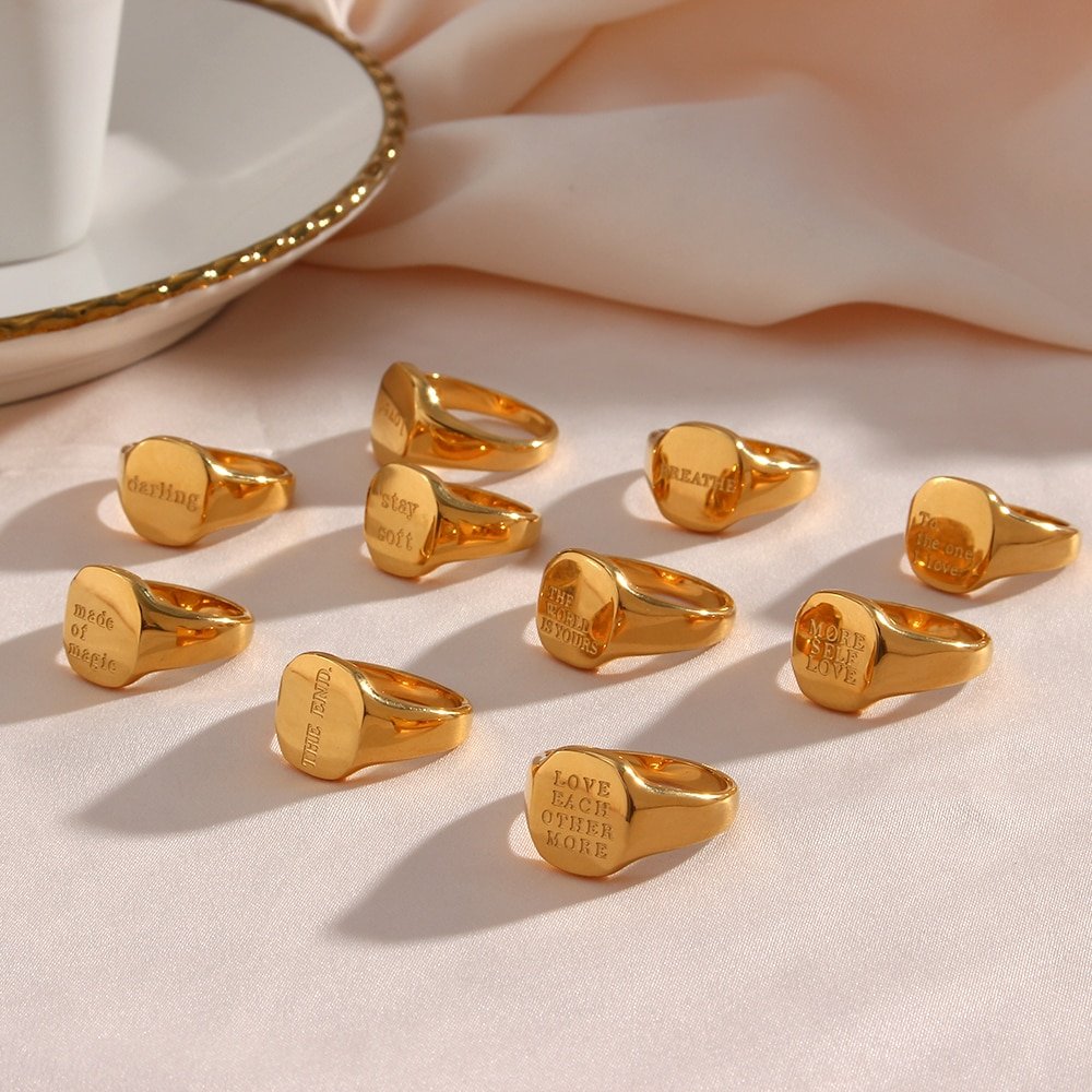 A bunch of gold Positive Message Signet Rings lined up.