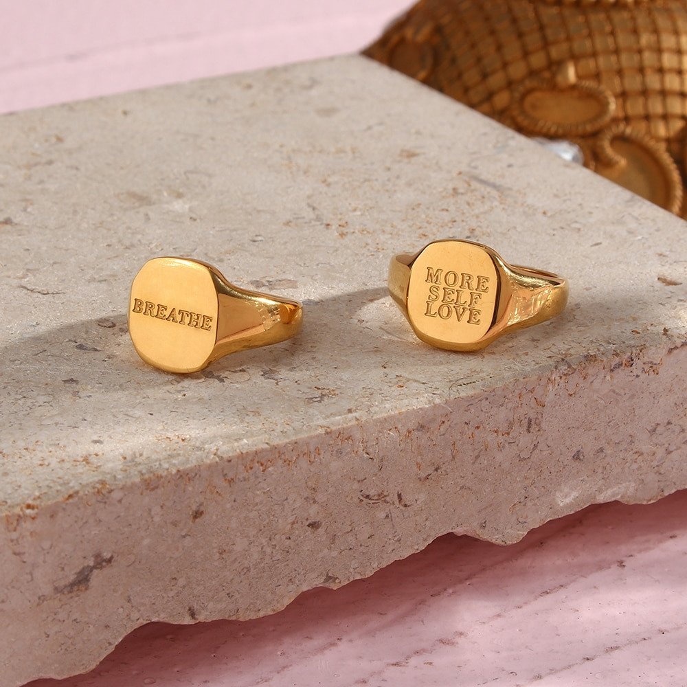 Two gold signet rings engarved with positve messages.