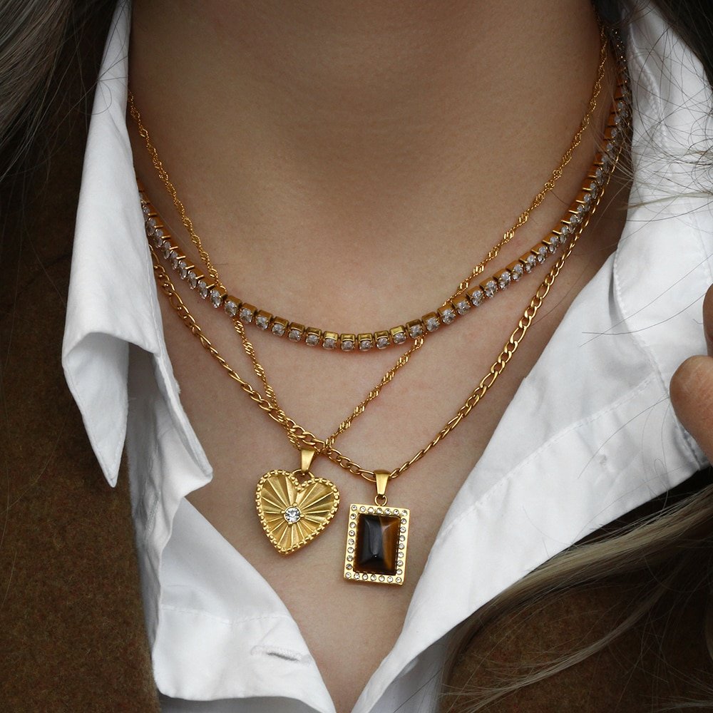 A model wearing multiple gold layering necklaces.