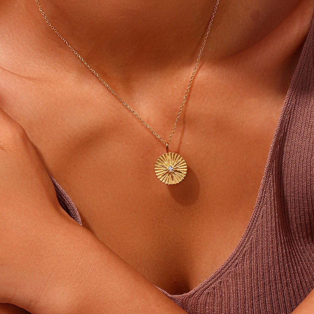A model wearing the Radiating Star Gold Coin Necklace.