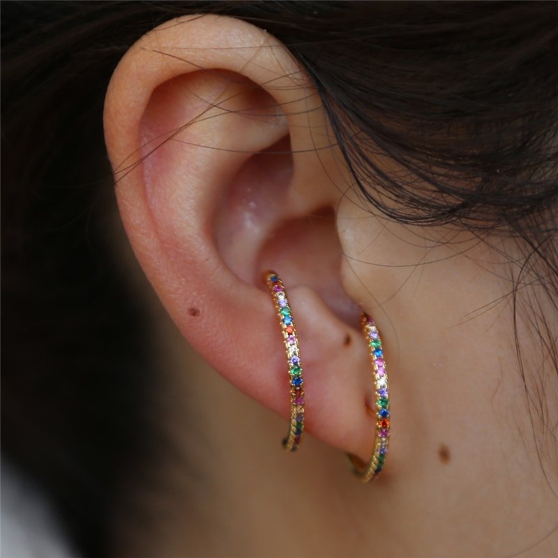 A model wearing two Rainbow CZ Suspender Earrings.