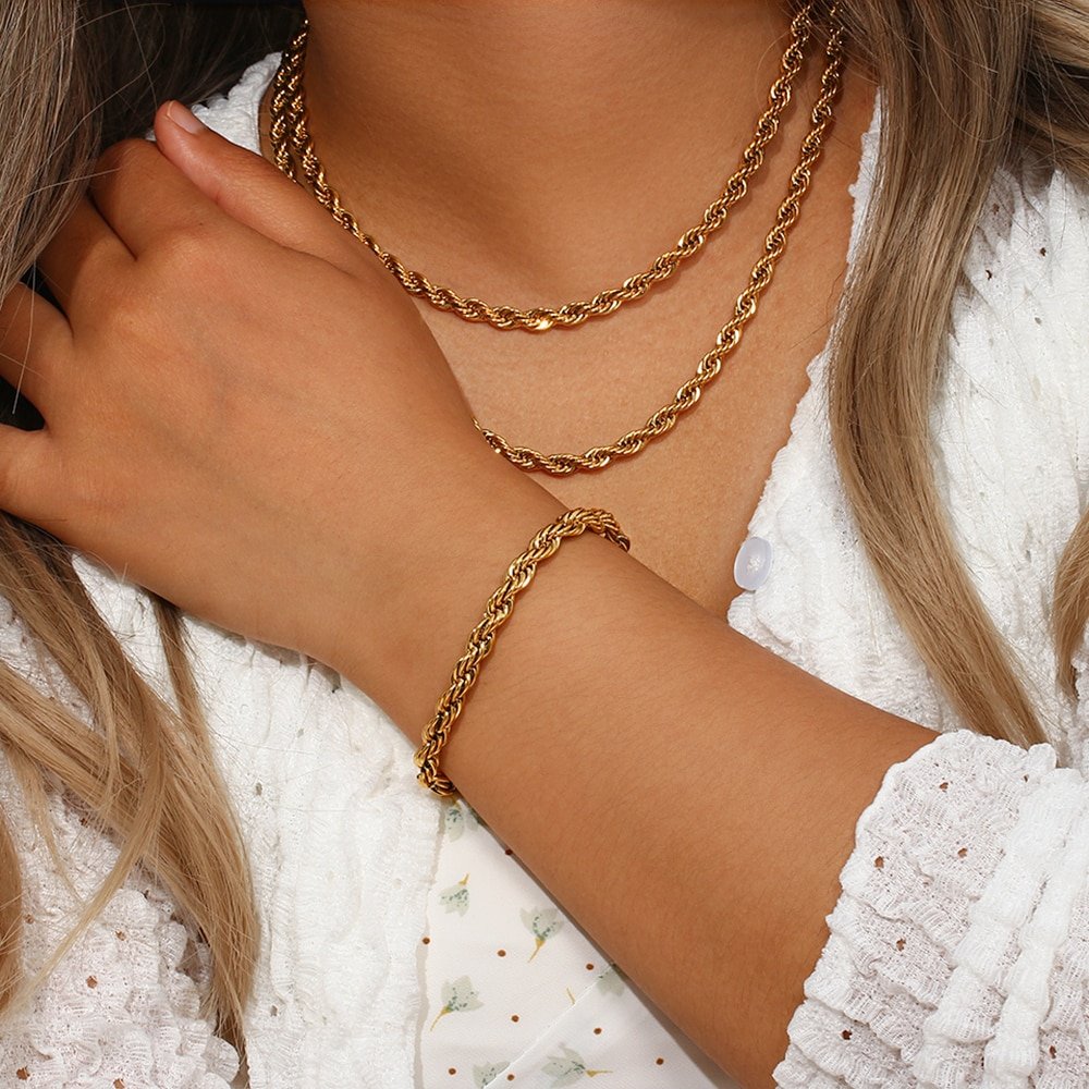 A woman modeling thick gold rope chain jewelry.