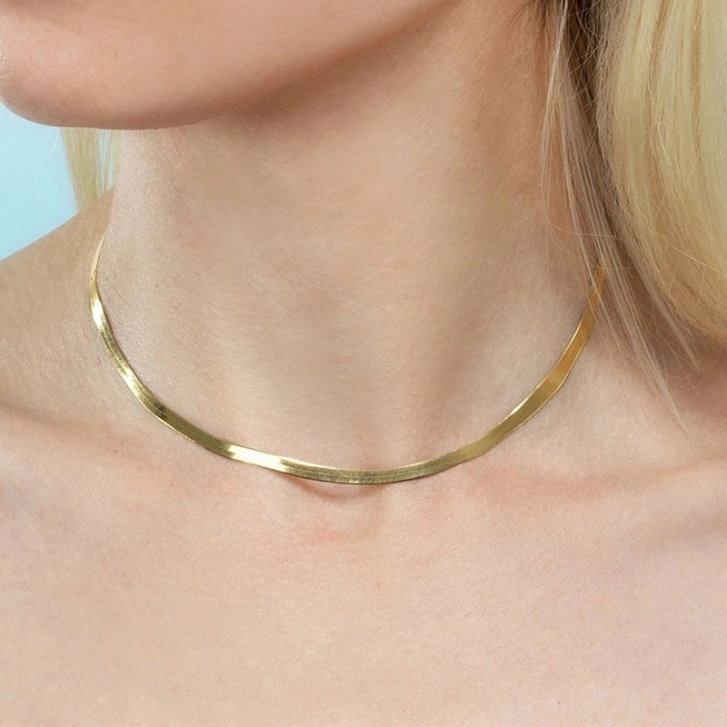 A woman wearing a retro gold chain necklace.