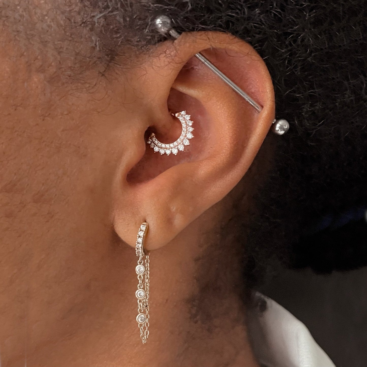 A woman wearing multiple cartilage piercings.