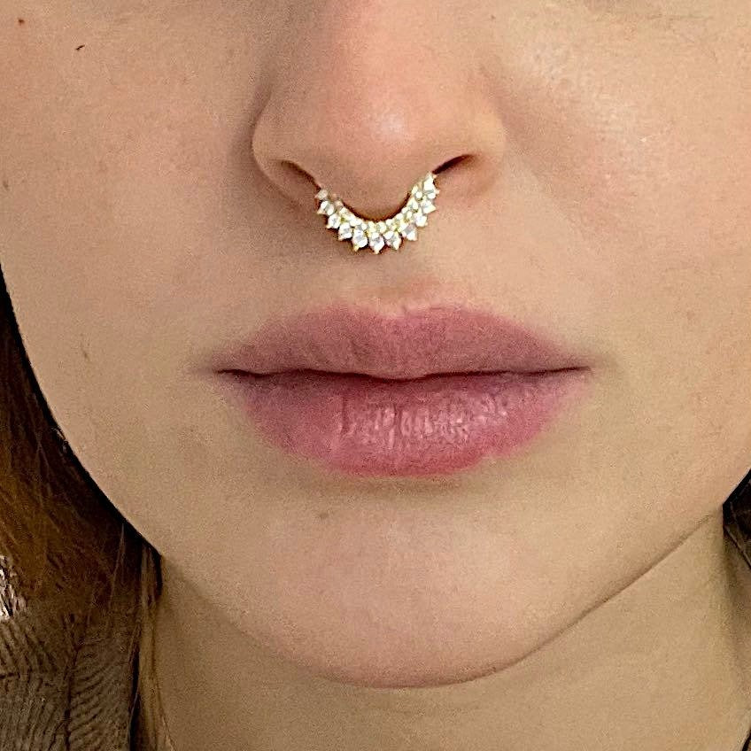 A woman wearing the Sadiki CZ Crown Cartilage Hoop in her septum piercing.