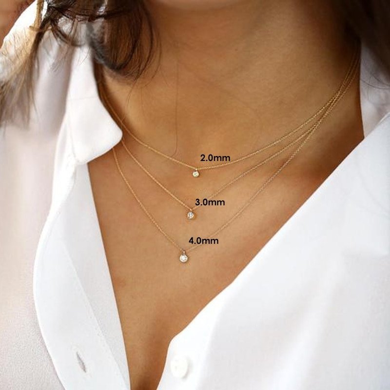 A model wearing three different sizes of the Short CZ Gold necklace.