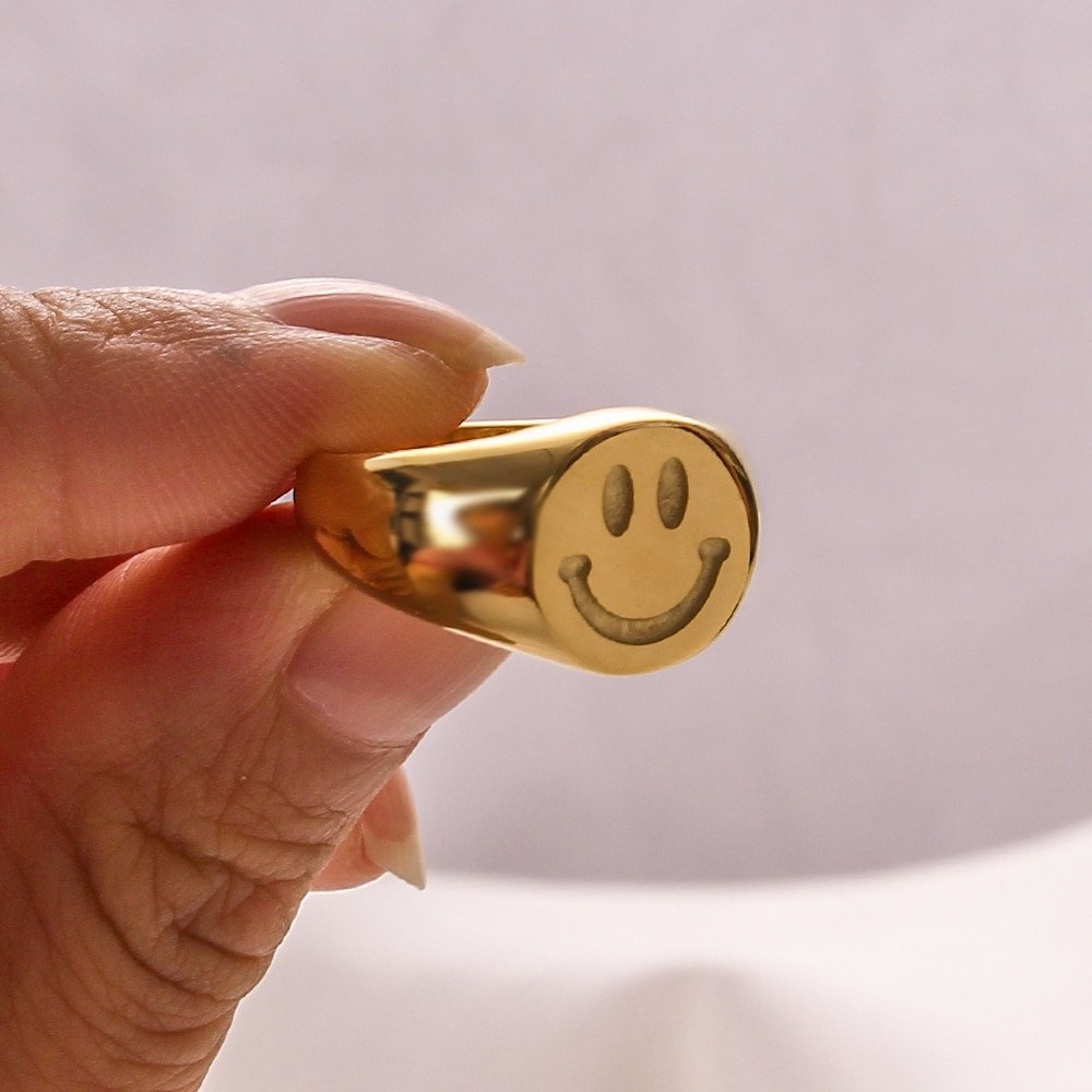 A woman holding the Smiley Signet Ring.