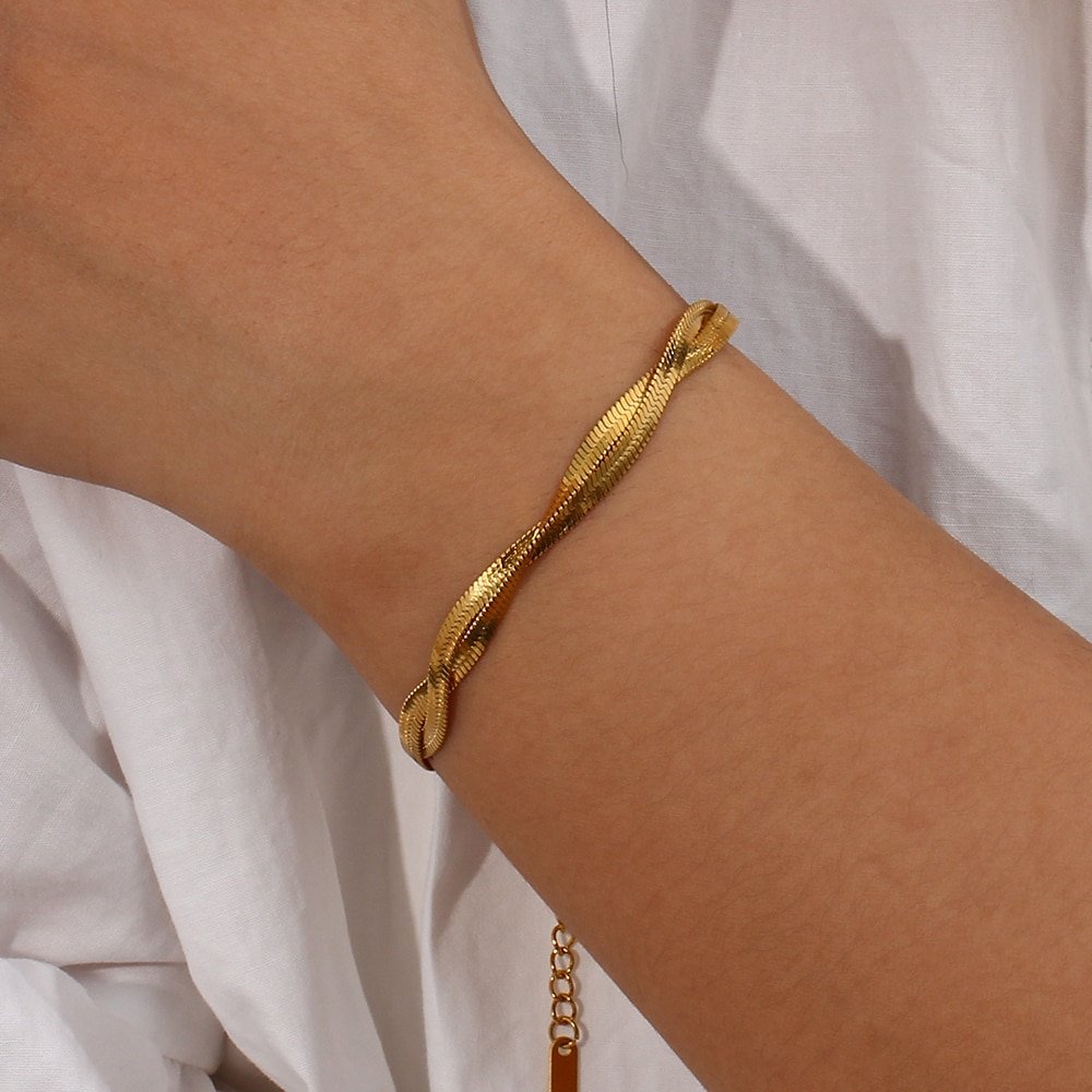 A model wearing a gold snake chain twist bracelet.