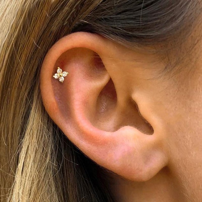 A model wearing the Sparkling Flower Studs in her cartilage.