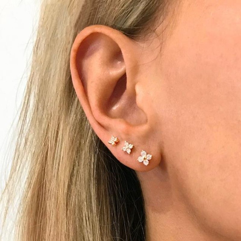 A model wearing three sizes of Sparkling Flower Studs.