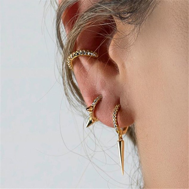 A model wearing multiple spike earrings.