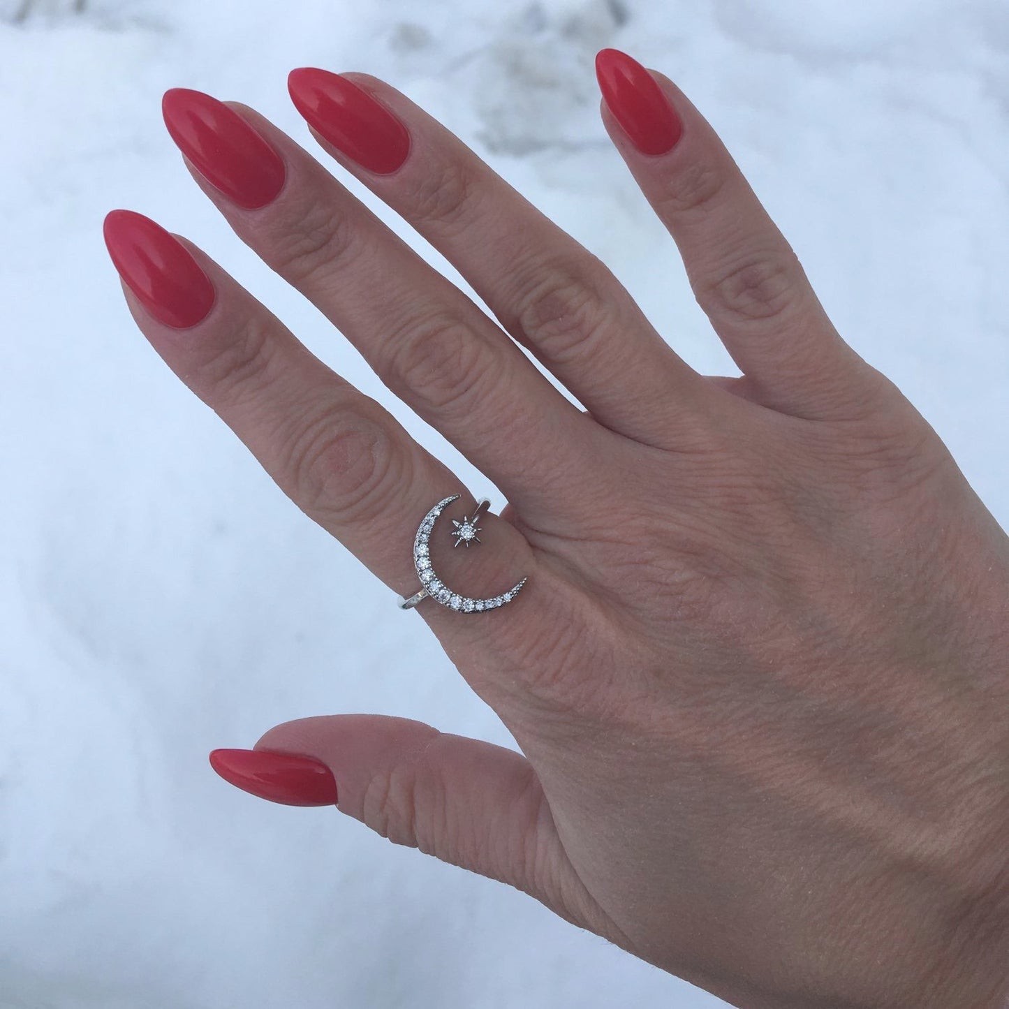 Star Crescent Moon Ring in silver being modeled on a woman's hand with red nail polish.
