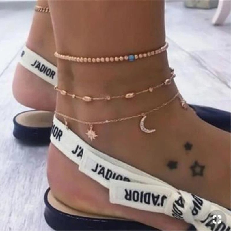A model wearing a multi anklet set with stars and moons.