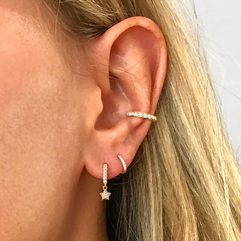 A model wearing huggie earrings with stars.